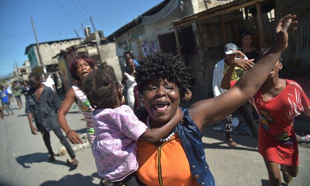 Haitians react to tear gas fired by the police in Port-au-Prince where there were reports of demonstrations, gunshots and burning tires. Photograph: Hector Retamal/AFP/Getty Images